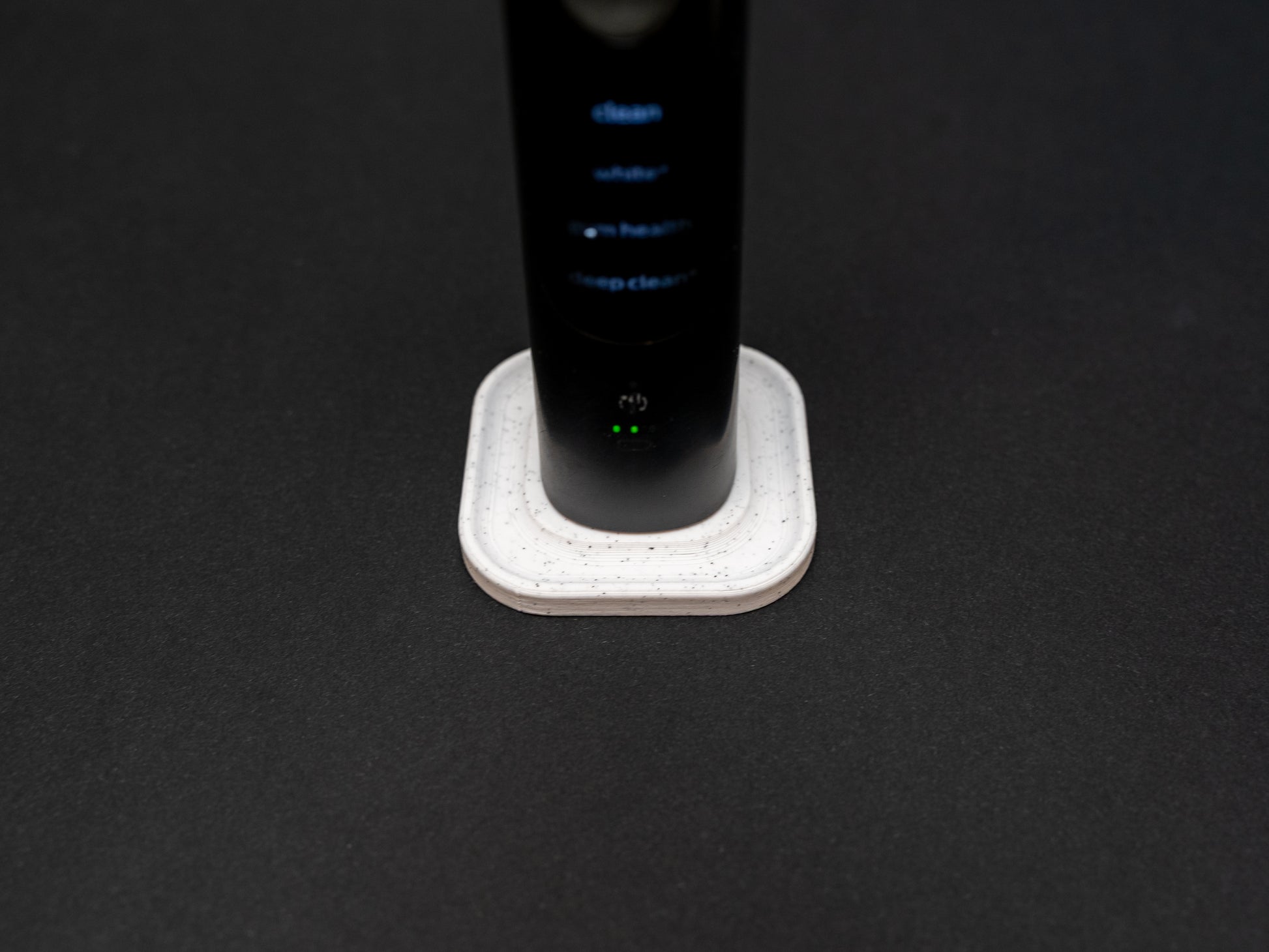 Philips Sonicare electric toothbrush stand that holds one toothbrush shown in white stone effect.