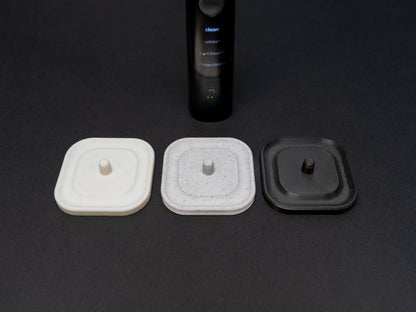 Philips Sonicare electric toothbrush stand that holds one toothbrush shown in white, white stone effect and black.