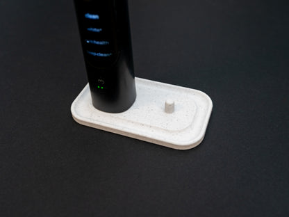 Philips Sonicare electric toothbrush stand that holds two toothbrushes shown in white stone effect.