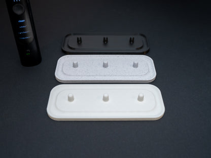 Philips Sonicare electric toothbrush stands that hold three toothbrushes shown in white, white stone effect and black.