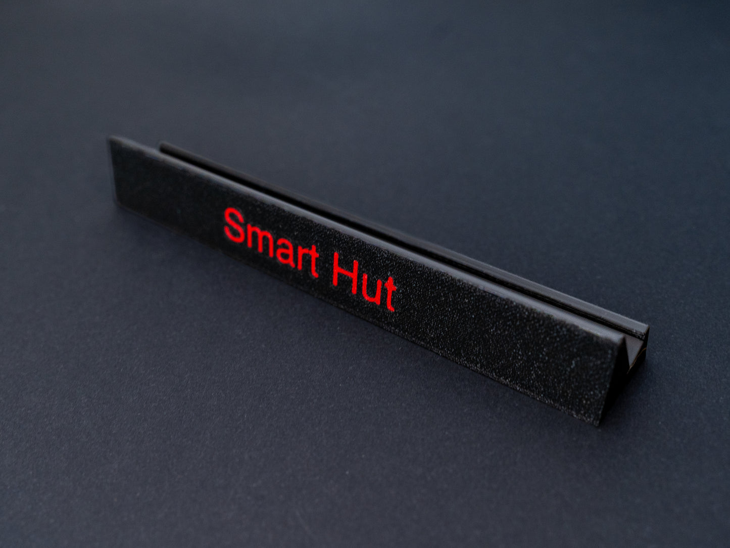 Personalised black scrabble and bananagrams tile holder. Shown with the personalisation in red text at the front and tiles in the tray at the back.