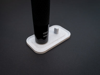 3D printed Oral B toothbrush stand in white marble stone colour on a black background. Picture shows a stand for two toothbrushes. Stops toothbrush from falling over and organises the bathroom