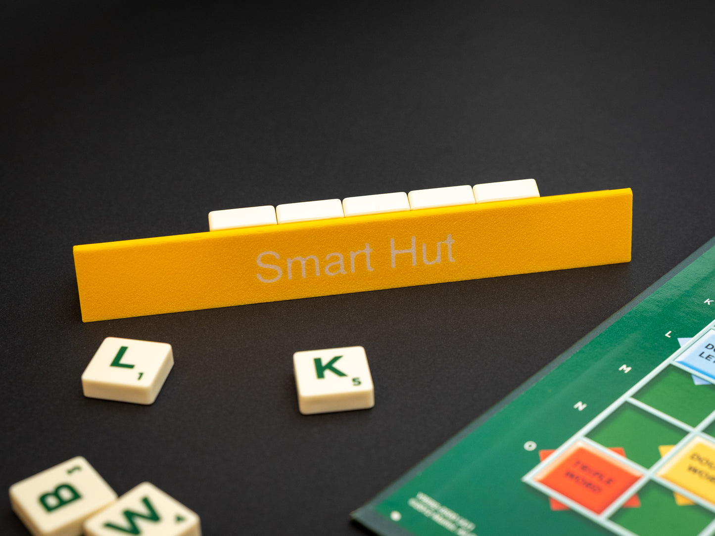 Personalised yellow scrabble and bananagrams tile holder. Shown with the personalisation in white text at the front and tiles in the tray at the back.