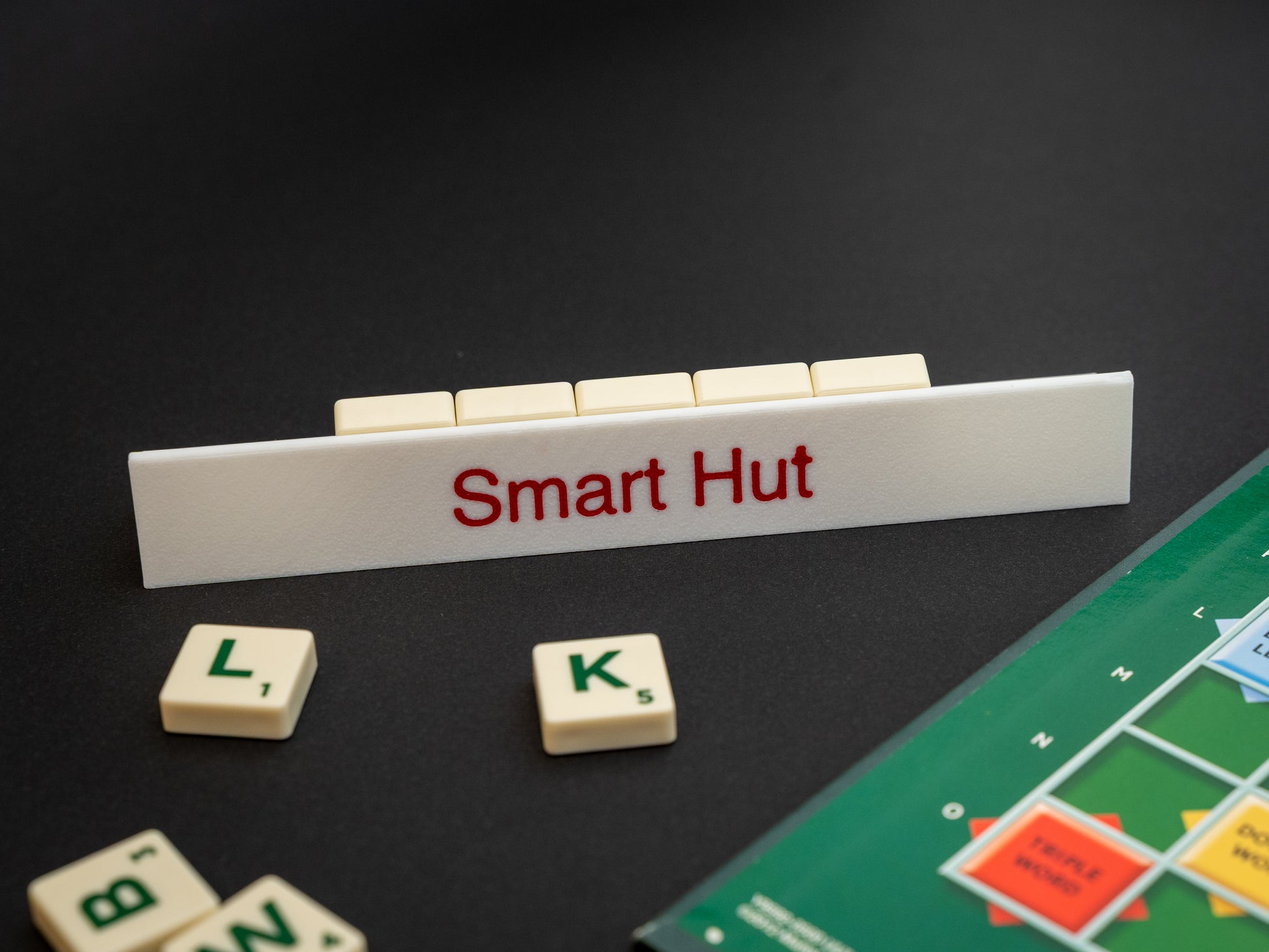 Personalised white scrabble and bananagrams tile holder. Shown with the personalisation in red text at the front and tiles in the tray at the back.