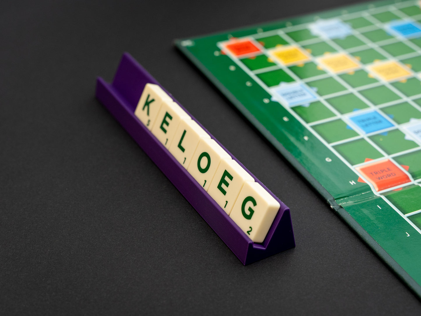 Personalised indigo purple scrabble and bananagrams tile holder. Shown from the side with tiles in the tray